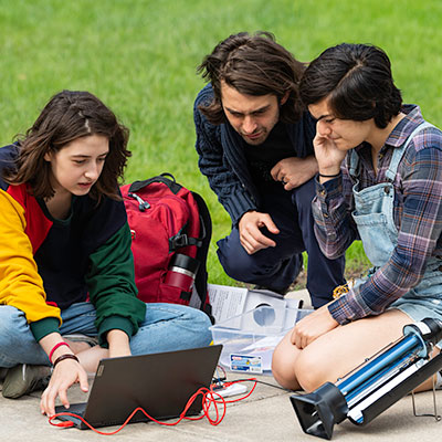 A professor works with students as they set up and test equipment.