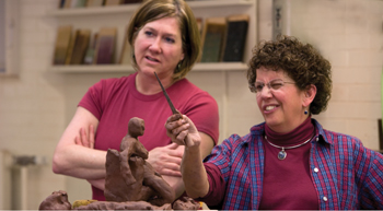art instructor helps student with sculpture