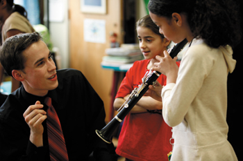 Eastman student plays clarinet with school children