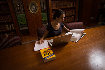 A student works in the Seward Room of Rush Rhees Library.
