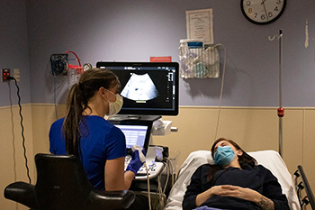 A resident using an ultrasound machine.