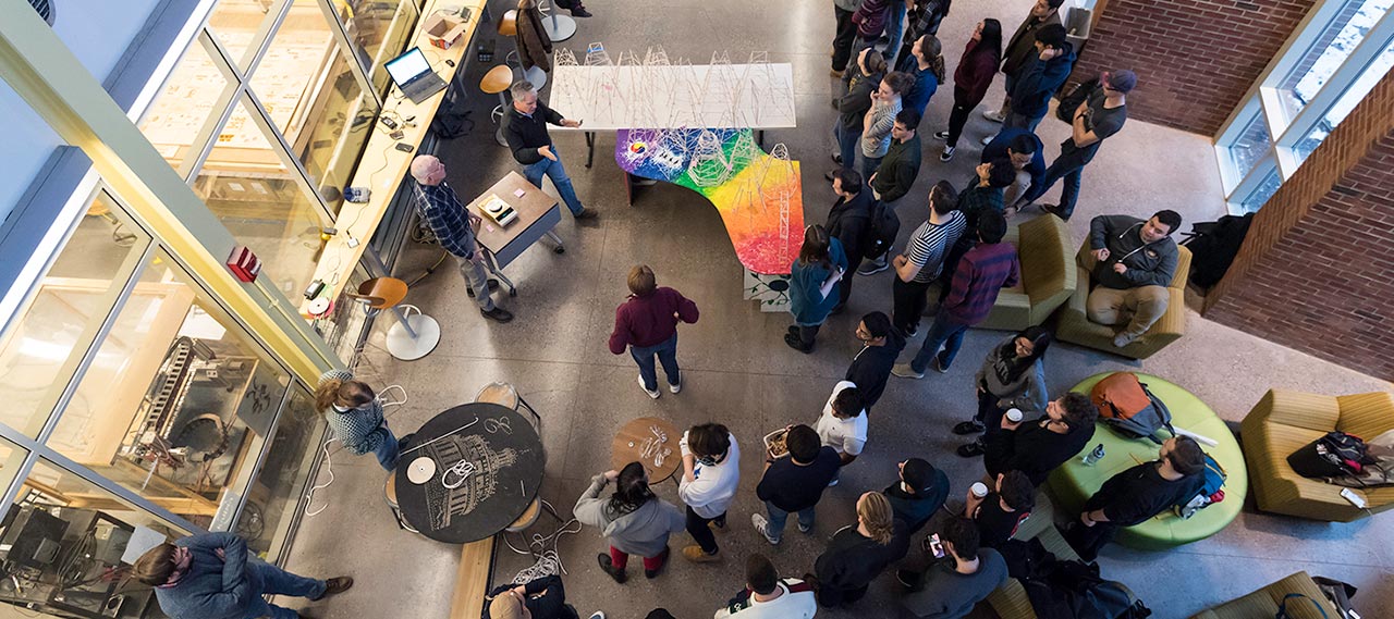 An overhead view of a professor explaining the rules to a student competition.