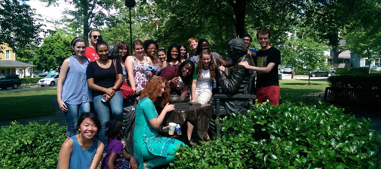 A group of student volunteers posing with the Frederick Douglass statue.