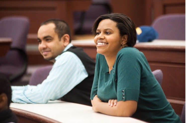 Two students in class smiling.