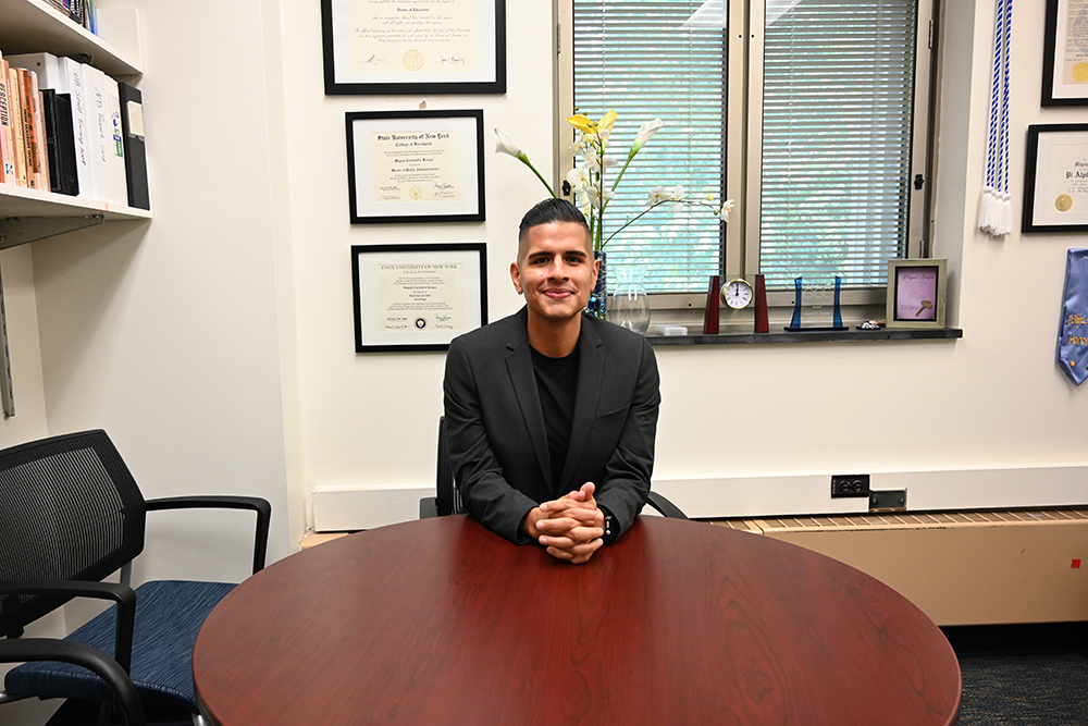 Miguel sitting behind a table in his office.