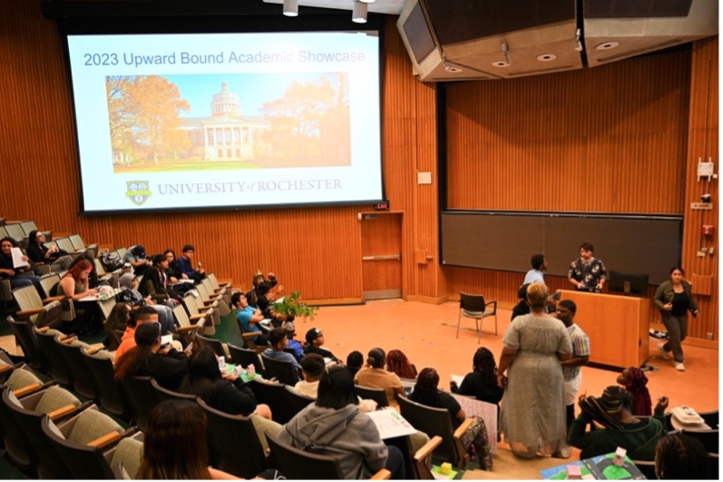 Students watching a presentation in an auditorium.