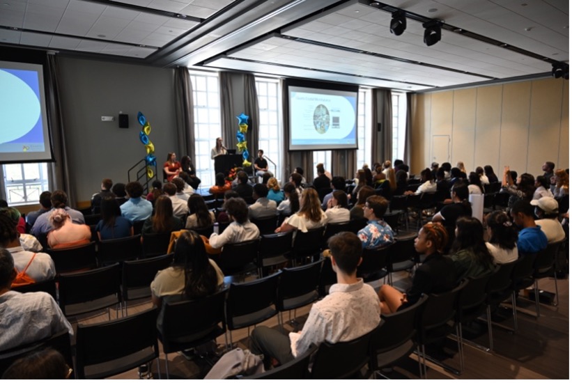 Students in an audience listening to a speaker.