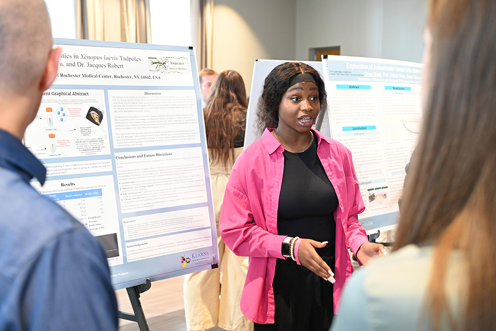 A student speaking about their research at the poster session.