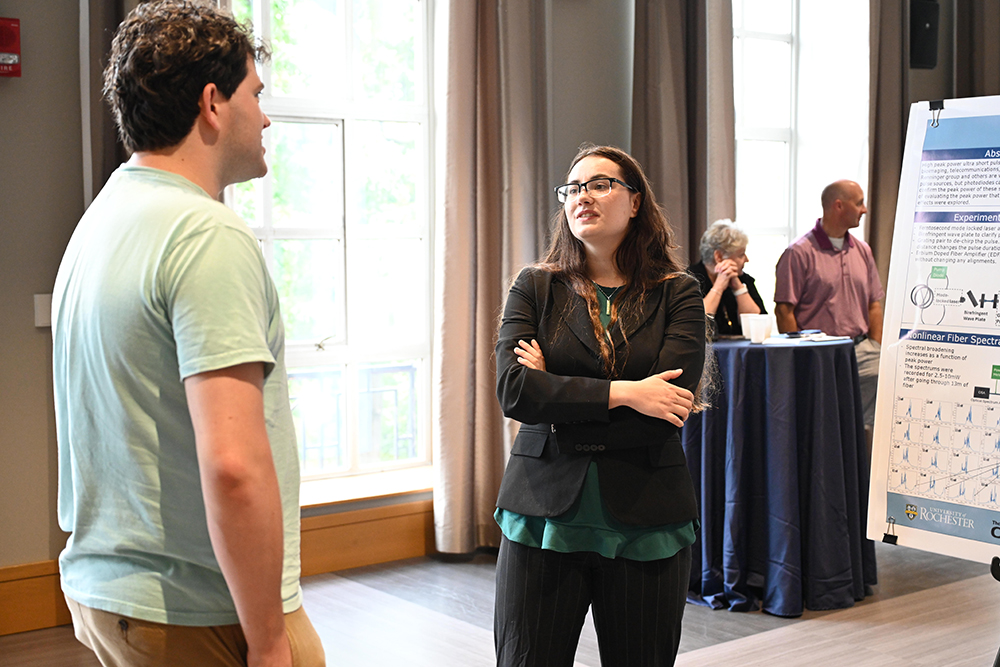 Two symposium attendees speaking at the poster session.