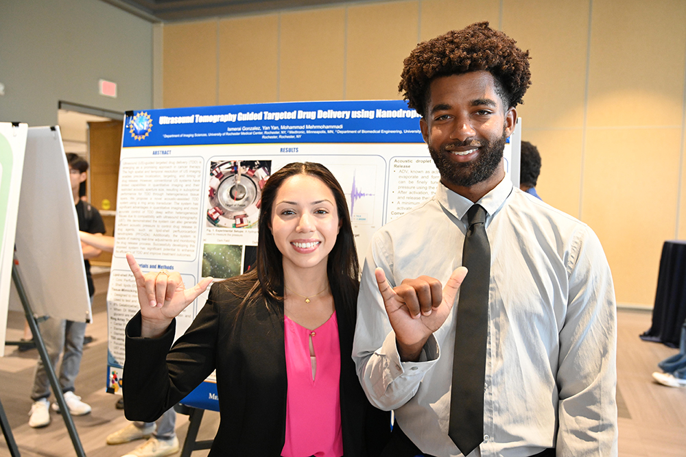 Two students posing for the camera with both using the Shaka sign.