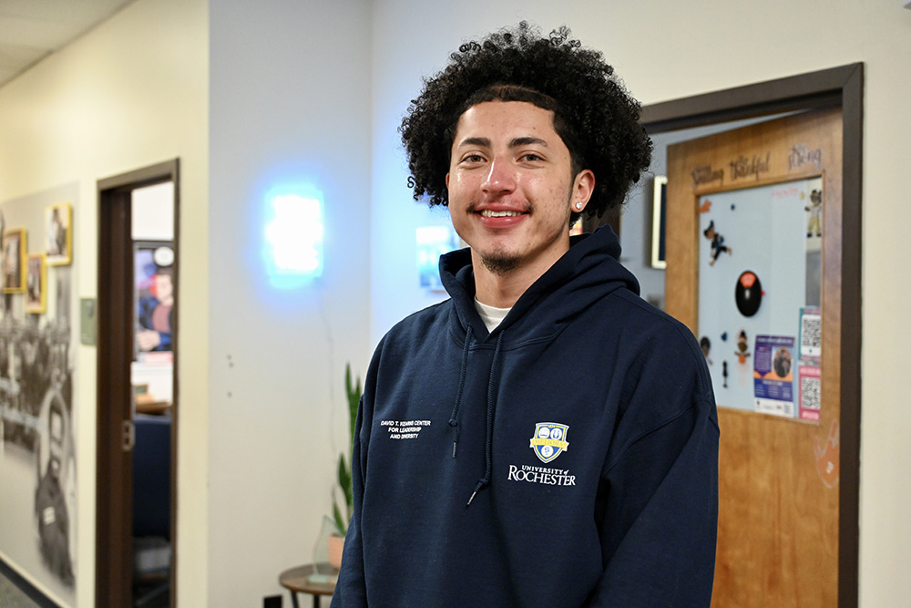 Oswald Garcia stands in the living room of the Kearns Center in Dewey Hall, March 2024. Photo: Alexa Olson, University of Rochester.