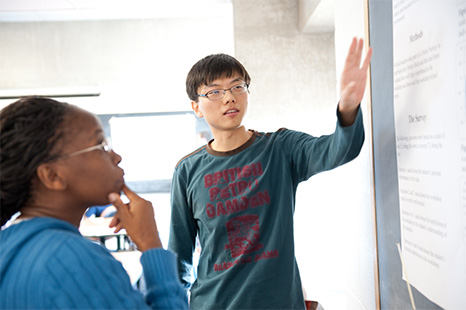 A tutor helping a student understand a problem on a blackboard.