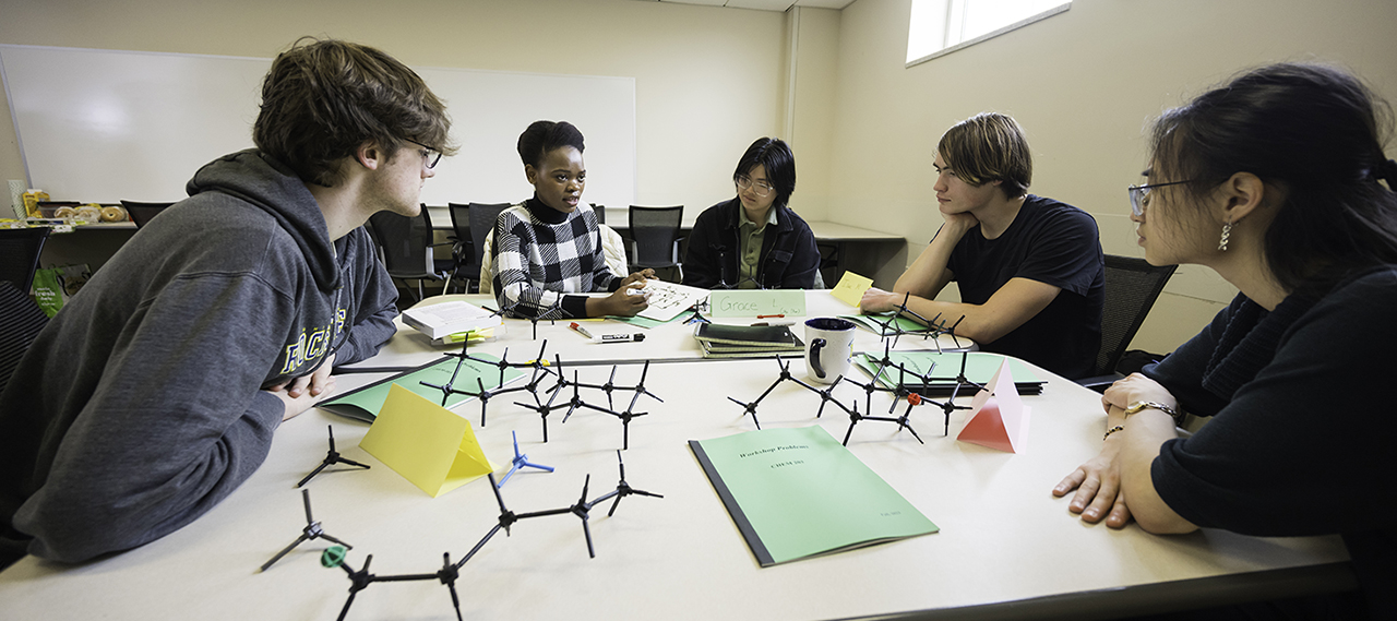 A group of students working around a table with tools.