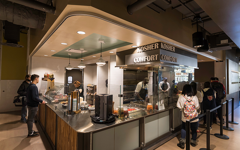 Photo of students lined up at one of the stations inside Douglass Dining Center