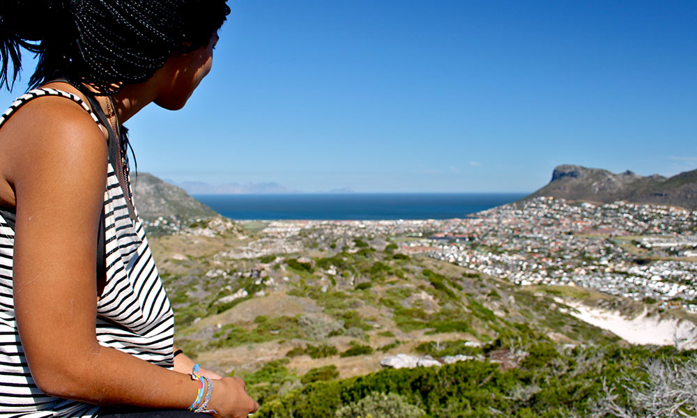 Woman gazing over a picturesque town in the distance.