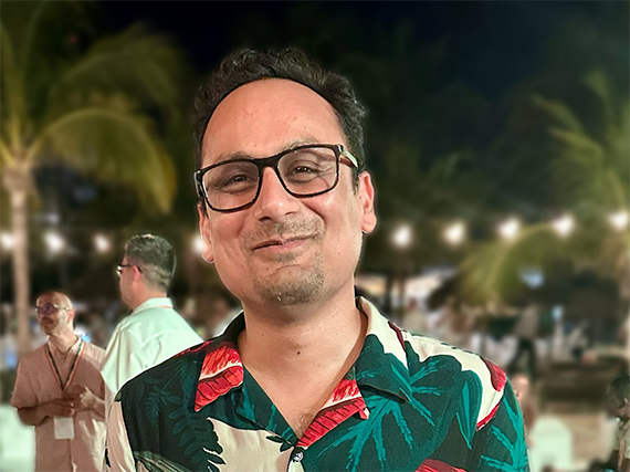 Ehsan Hoque smiles at the camera while wearing a Hawaiian shirt