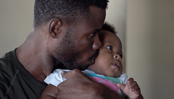 Black father kisses baby