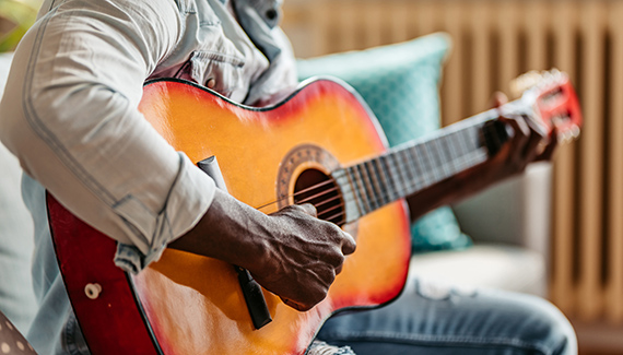person plays acoustic guitar