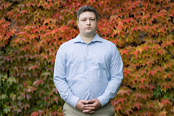 Garrett Boehmer stands in front of red and yellow fall folliage.