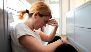 sad, stressed person sits on floor