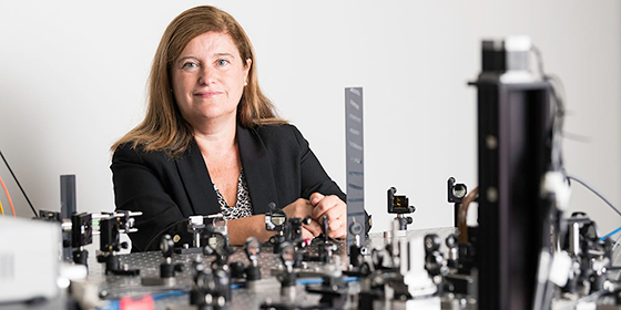Susana Marcos stands in front of an optical bench.