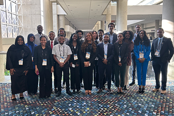 A group photo of members of Rochester’s chapter of the National Society of Black Engineers (NSBE) at a convention center.