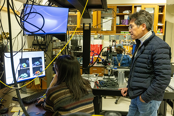 Jong Hoon Nam observes a student working in his lab.