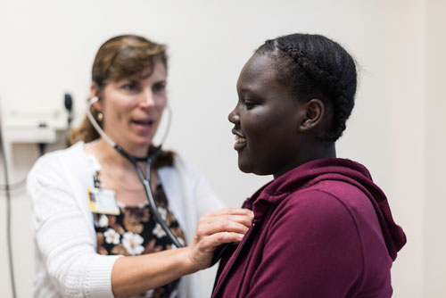 East High student Annan Lamin (R) is pictured during a visit with nurse practitioner Joan Stack at the University of Rochester Health Center at East High School in Rochester, NY