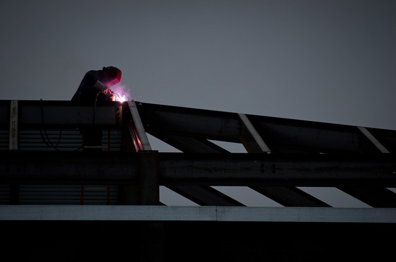 Ironworkers weld beams