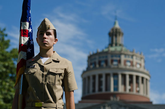 midshipman with flag in front of Rush Rhees Library