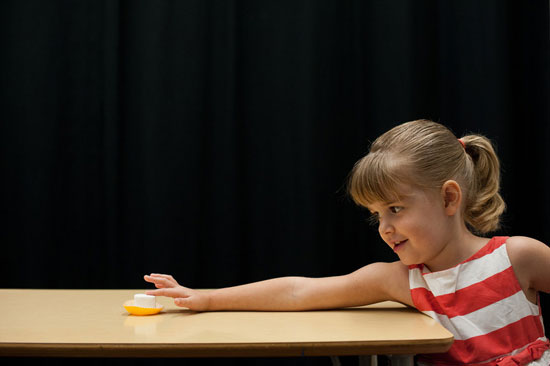 girl reaching for marshmallow