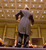 conductor on stage facing the orchestra