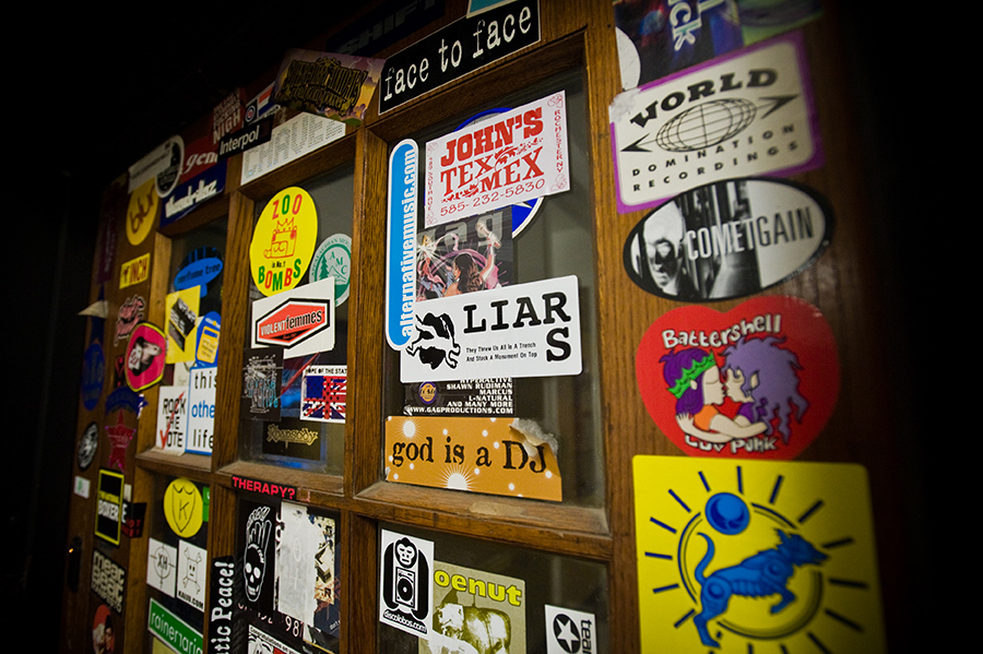 door to a radio station is covered top to bottom in stickers for bands, artists, causes, and more