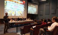 Jonathan Burdick addressing an auditorium of students and panelists