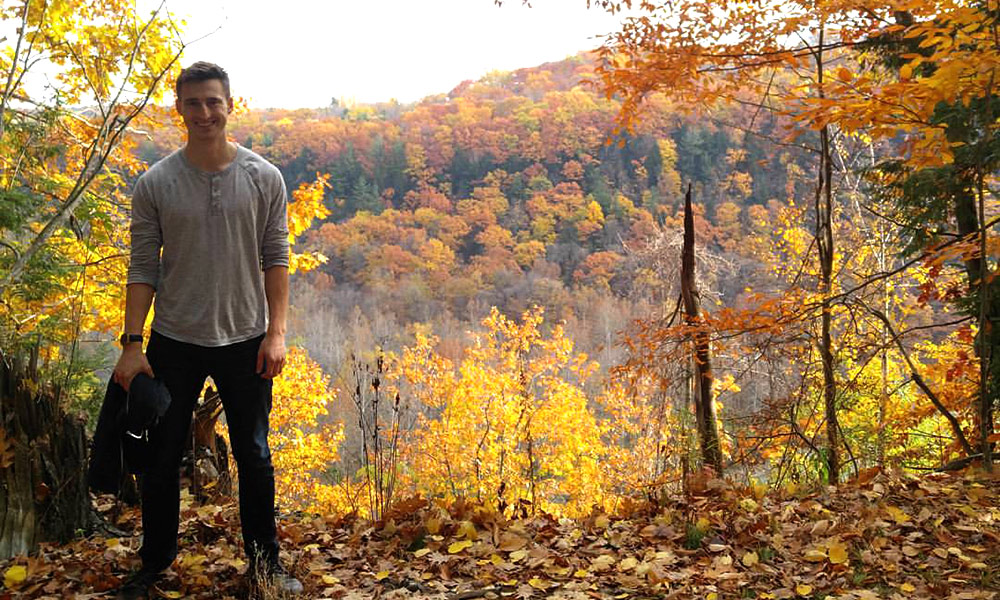student standing among fall trees at Letchworth State Park