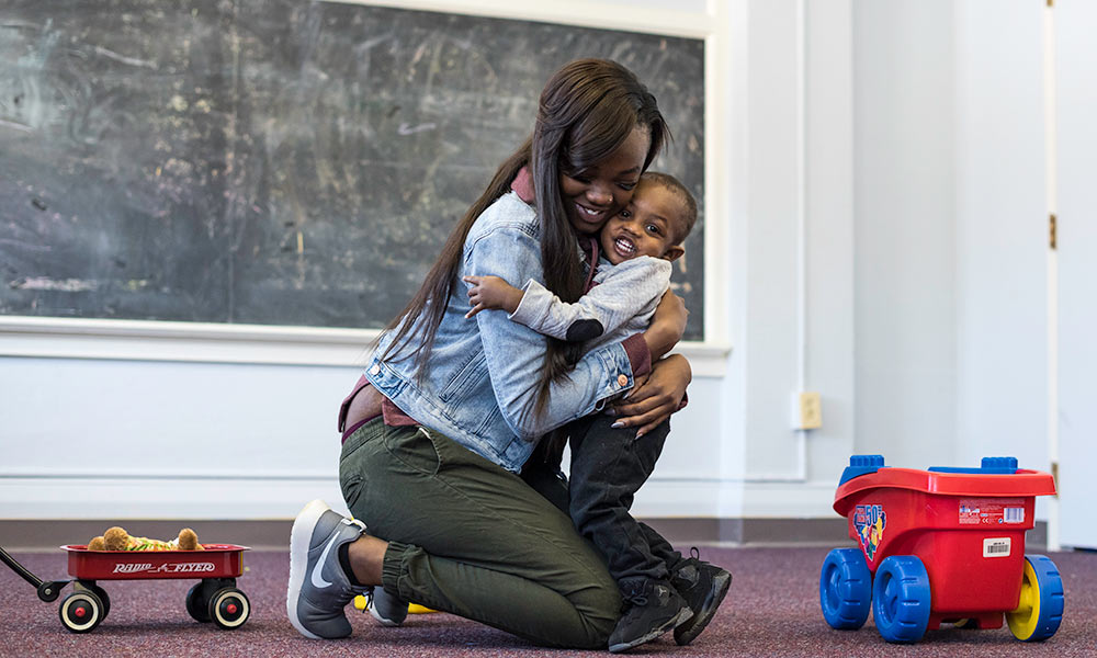 mom hugs her son in a classroom