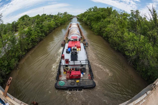 large barge in the Erie Canal holds three very large tanks