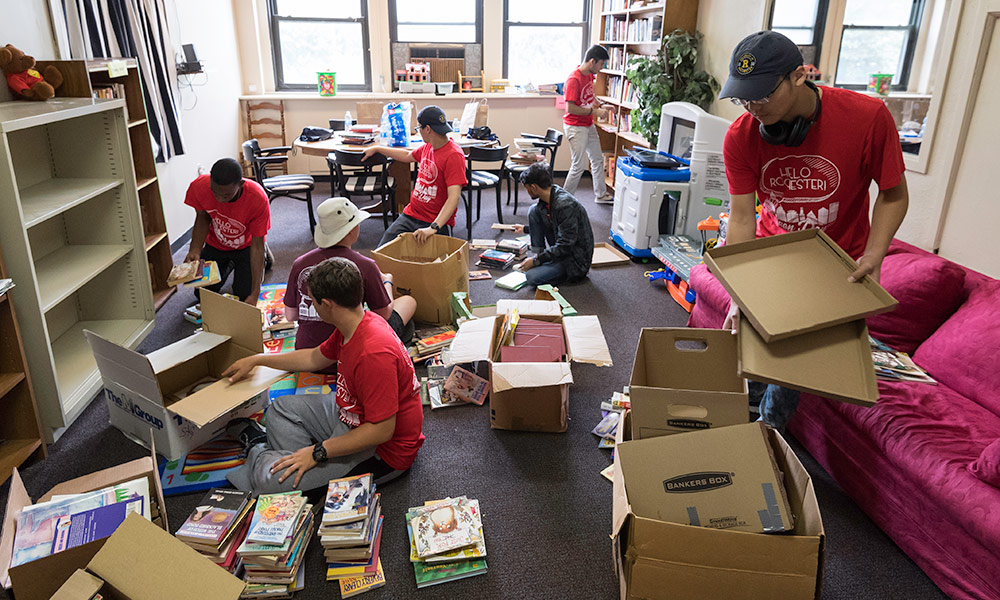 students organizing boxes of books in a classroom 
