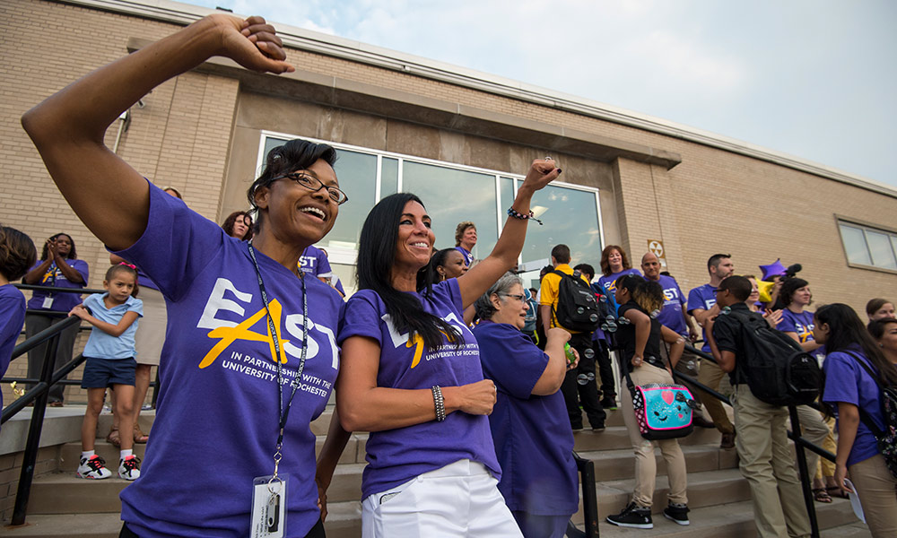 teachers and staff shouting and celebrating as students enter East High School