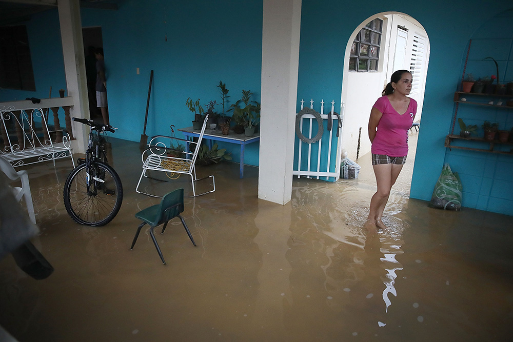 woman standing in water in her flooded home in Puerto Rico