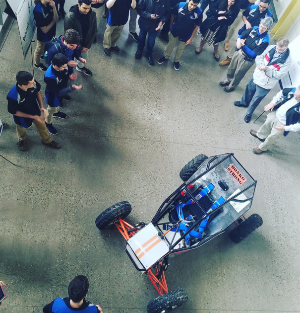 crowd of people gathered around a racing car