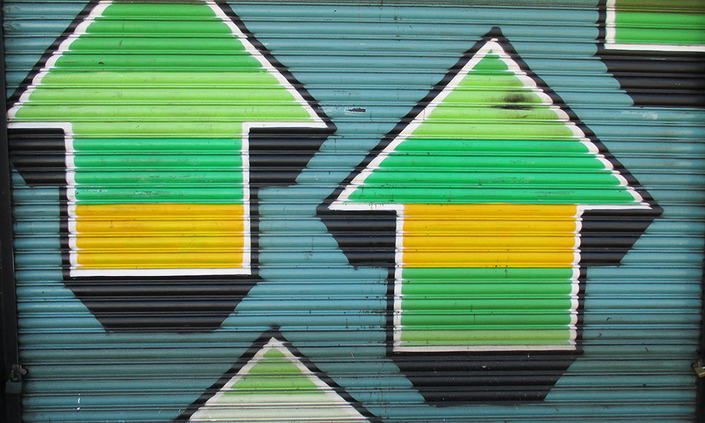 graffitti on a wall showing arrows pointing up and down