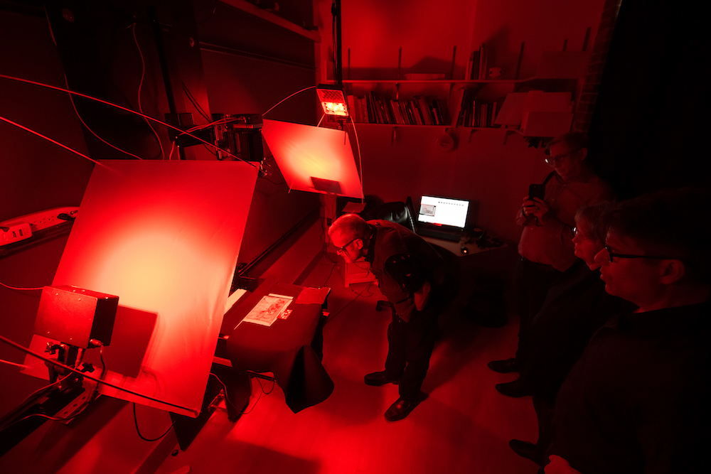 Water-damaged "safety envelopes" from the bursar's vault of the Titanic are scanned in a lab bathed in red light