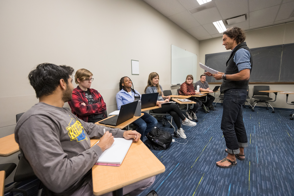 Small classroom with six college students and a professor