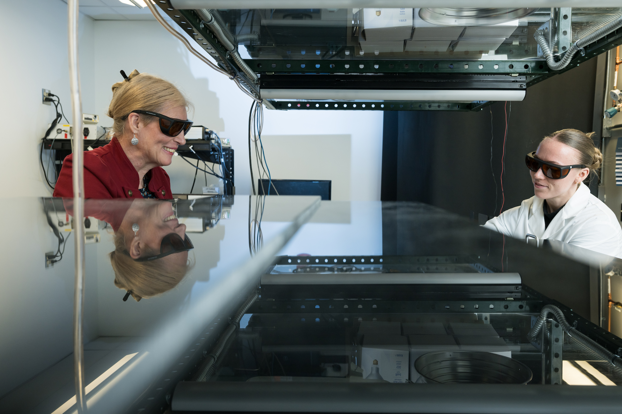 Two scientists sit across from each other in a lab