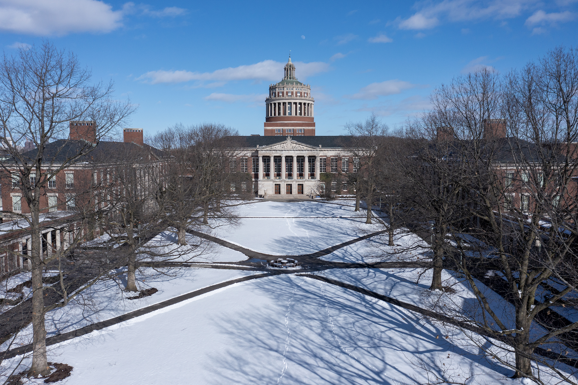 Snow covers the ground of the Eastman Quad, Rush Rhees Library ahead