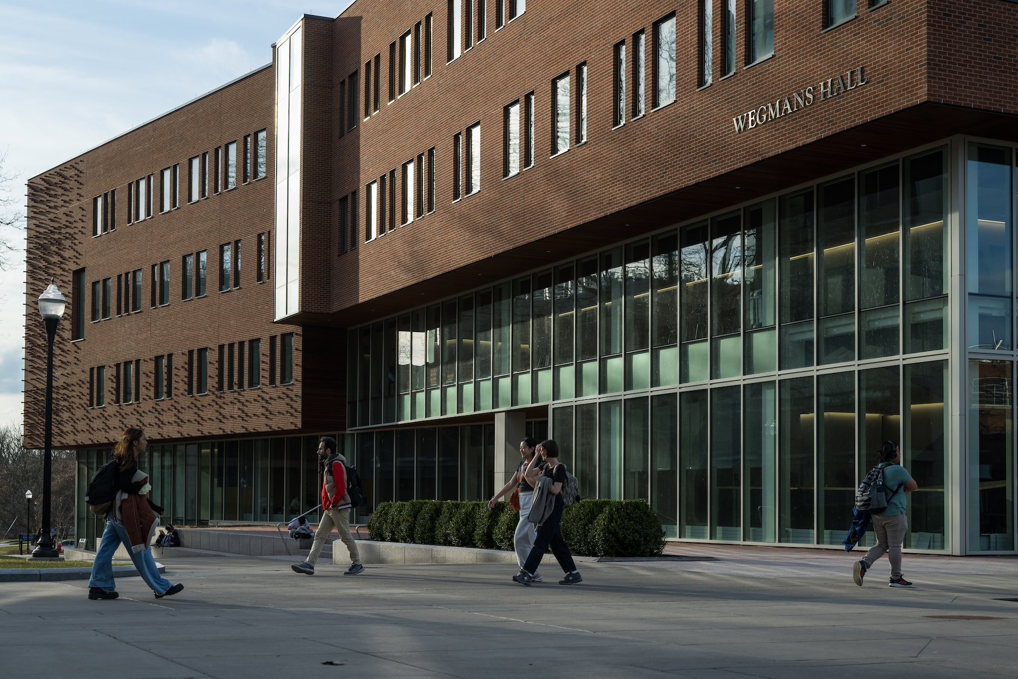 Several students walk through a college quad on a sunny spring day