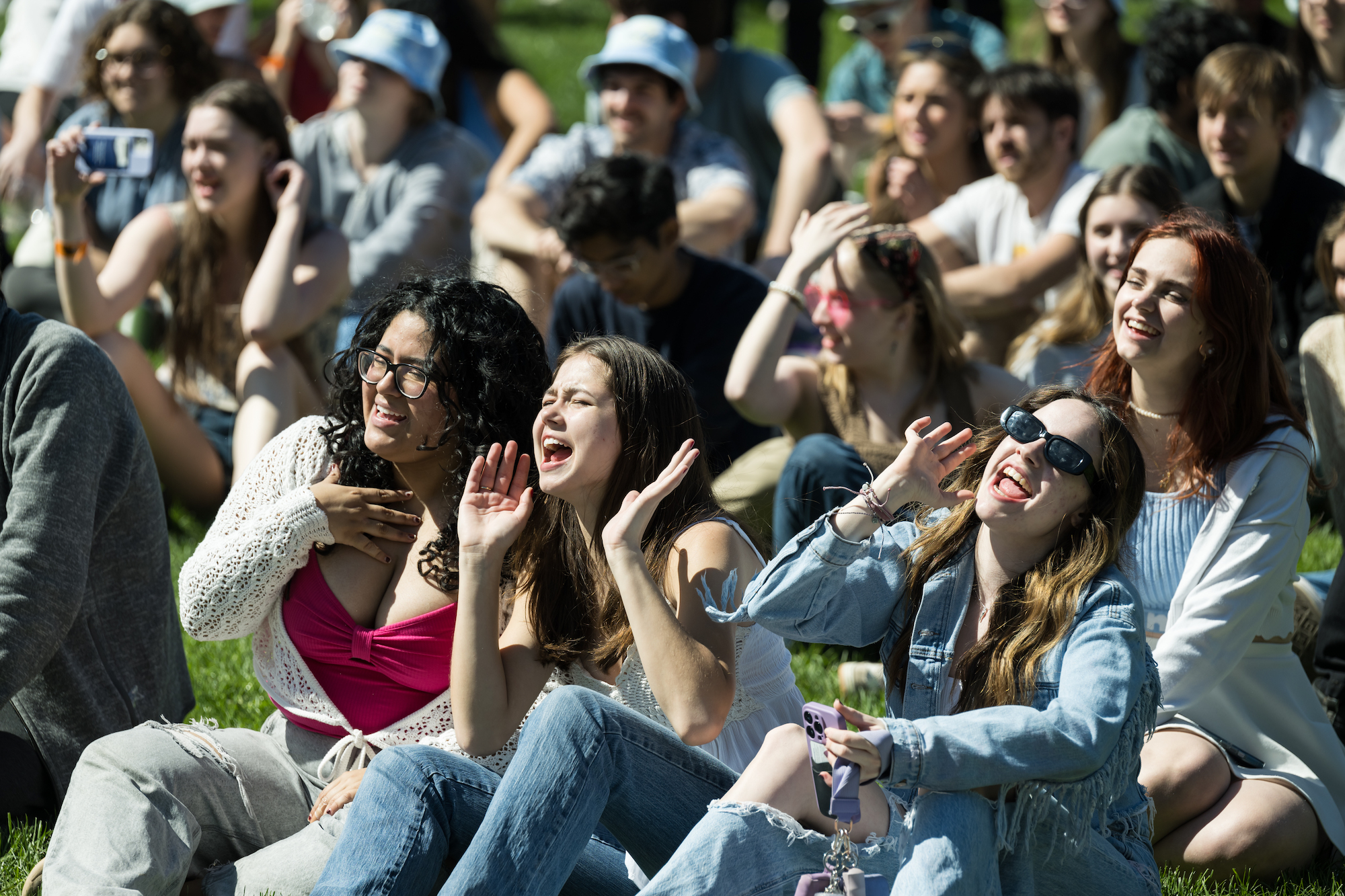 Students sitting outdoors, singing