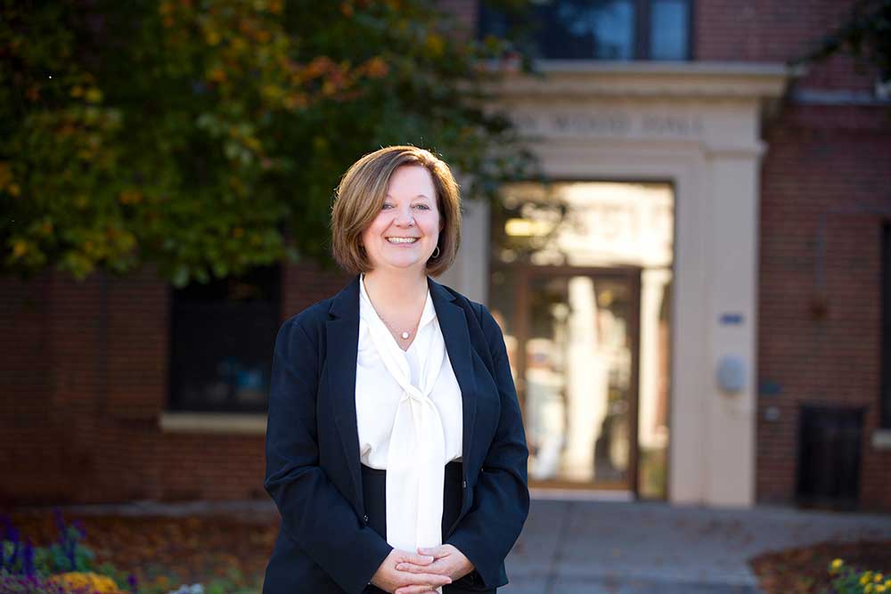 Lisa Kitko stands in front of School of Nursing building.