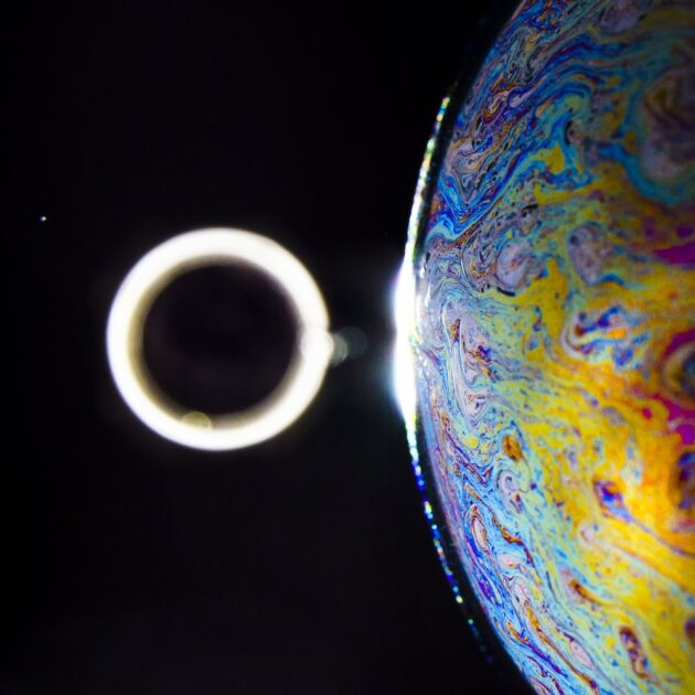 swirls of color in an orb with a circle of light beside it.